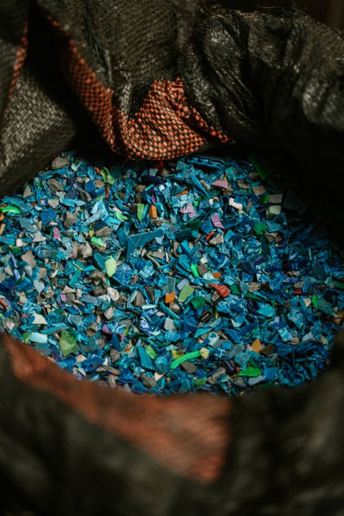 Free Detailed close-up of colorful recycled plastic fragments in a black sack, showcasing sustainability. Stock Photo