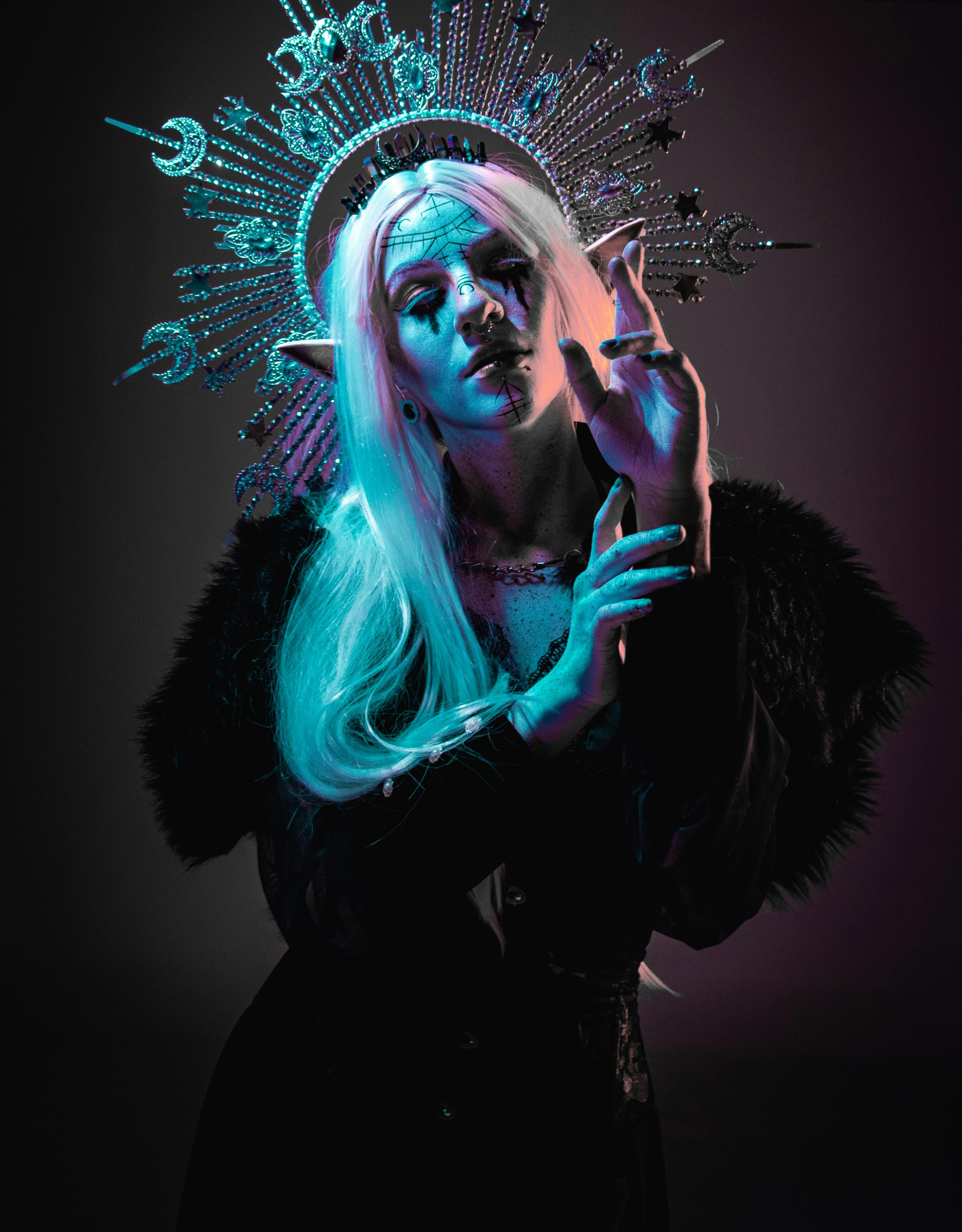 A striking portrait of a woman in fantasy attire with a radiant headdress, exuding mystery and elegance.