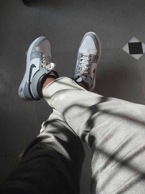 Legs in Gray Pants and Nike Sneakers