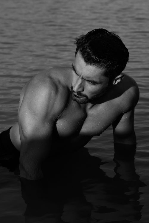 Free A shirtless muscular man in water captured in a black and white photograph. Stock Photo
