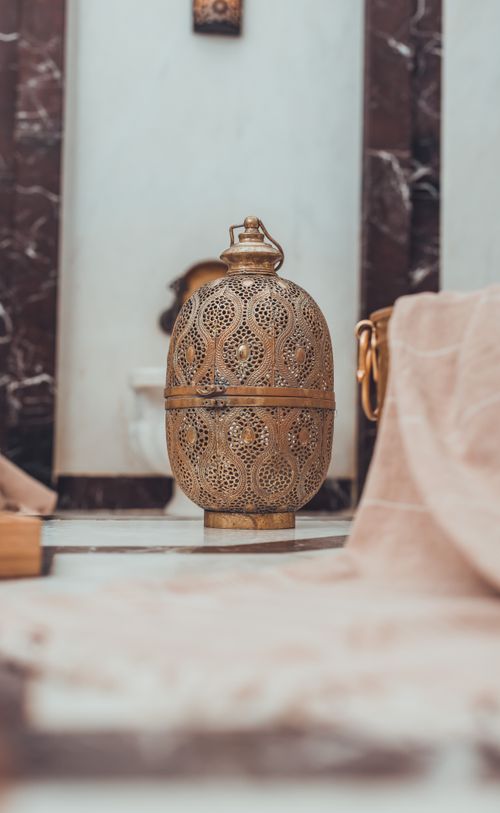 Free Intricately designed gold lantern in a vintage-themed, oriental setting with soft fabric drapes. Stock Photo