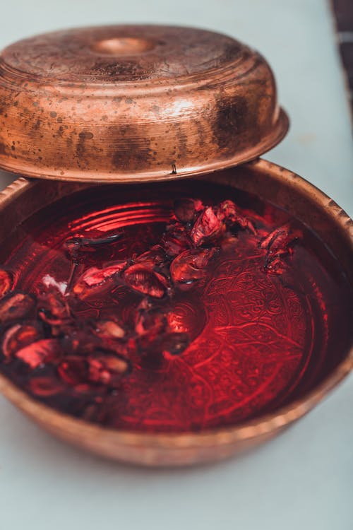 Close-up of a Copper Container with Red Liquid Inside 