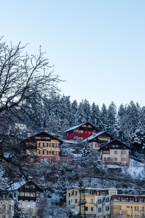 Free Idyllic winter view of a snow-covered village nestled in the mountains with traditional houses. Stock Photo