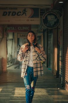 Model walking through a corridor in casual attire, perfect for fashion editorials.