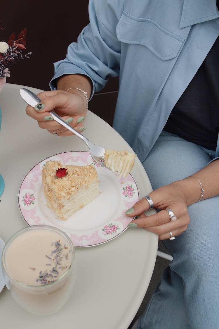 Woman Eating Cake With Fork In Cafe