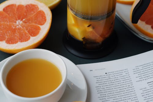 Photo of a Cup of Tea, a Glass of Juice and a Slice of Orange