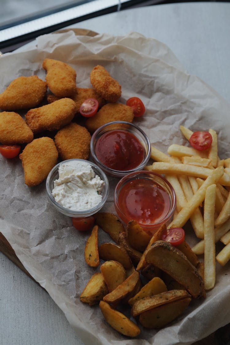 Wedges, French Fries And Nuggets On A Baking Paper