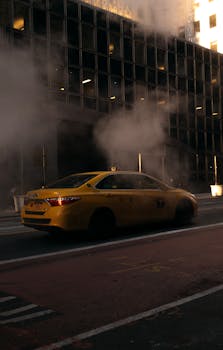 A yellow taxi navigates through a smoky street in New York City, encapsulating urban life.