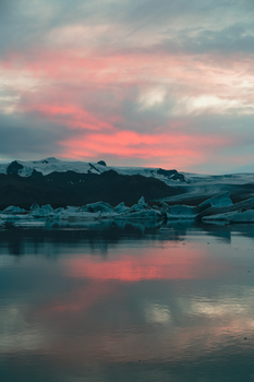 Captivating dusk view of Icelandic glacier reflecting in the serene waters near Reykjavik.