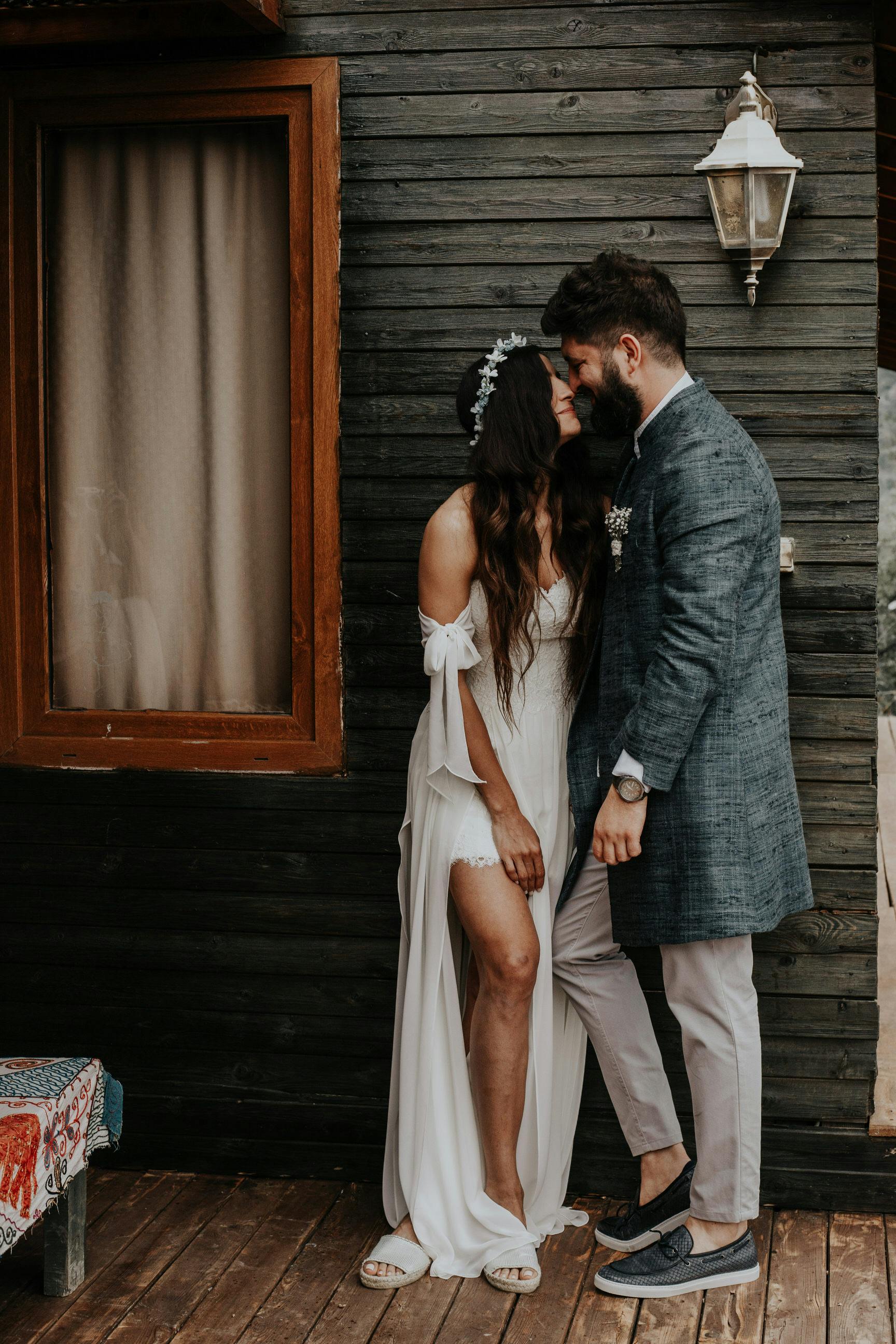 A bride and groom share an intimate moment in a rustic setting.