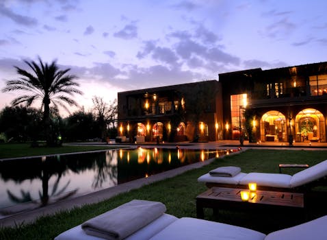 Elegant resort in Marrakech with a serene poolside view and illuminated architecture at dusk.