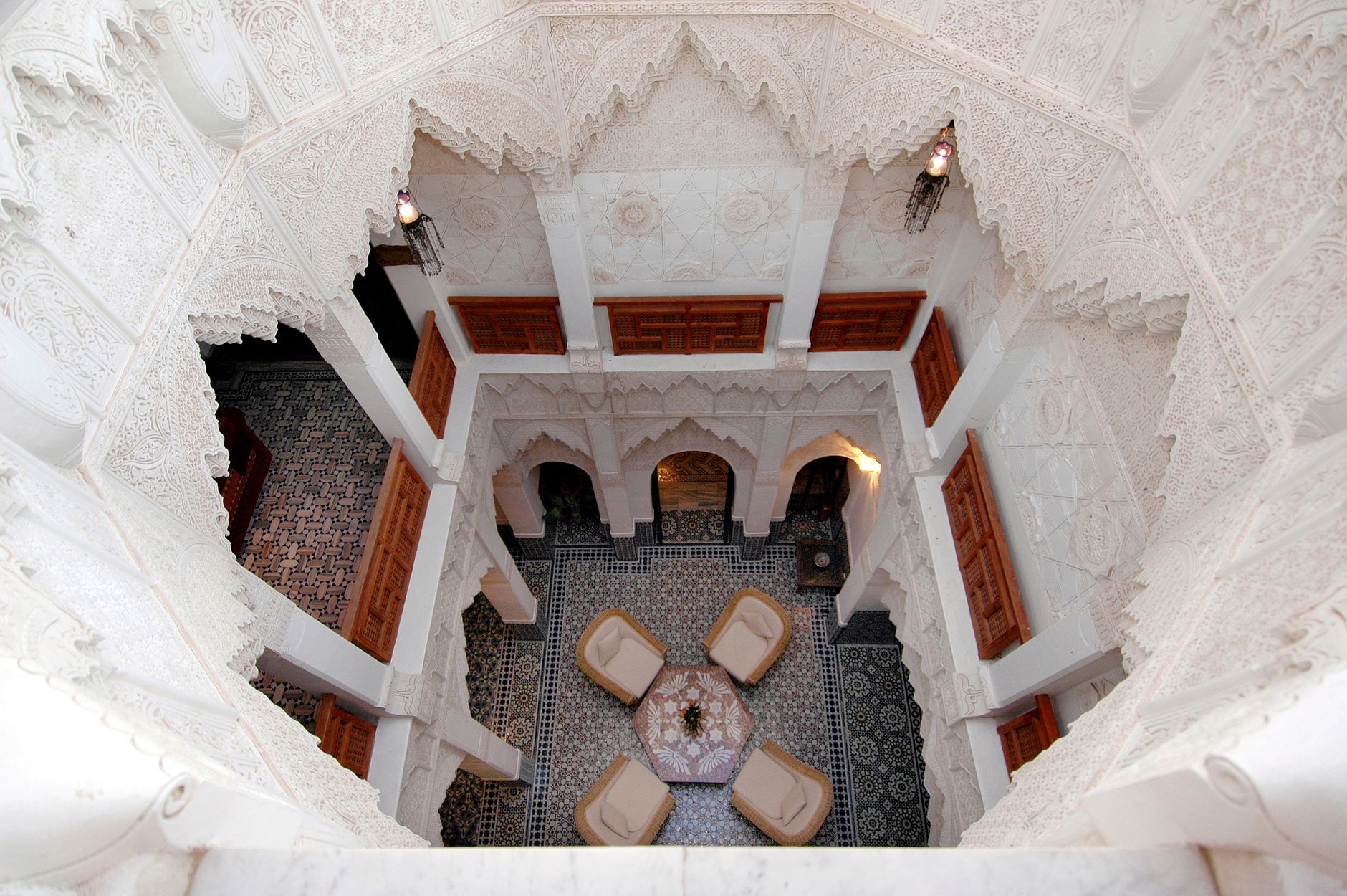Stunning high-angle view of a traditional Moroccan riad courtyard in Marrakech, showcasing intricate architecture. Related image for Hospitality in Africa: Key Lessons for Owners and Operators.