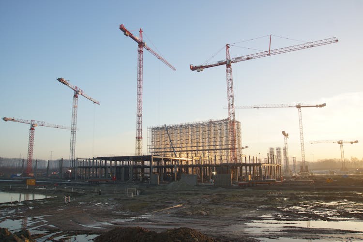 Cranes At Building Site On Sunset