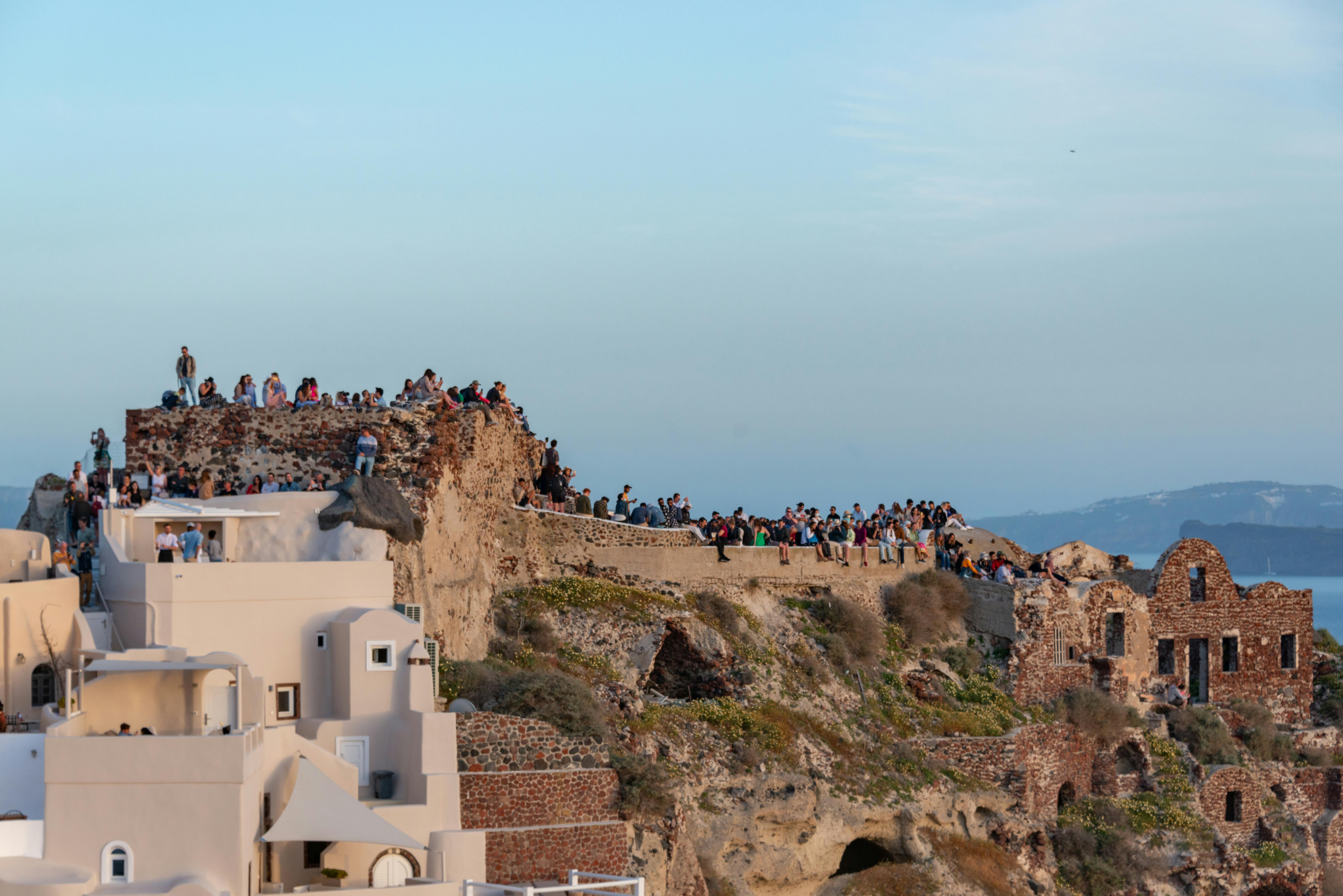 A group of friends enjoying a sunset view over the Aegean Sea in Santorini, Greece - best girls trip locations