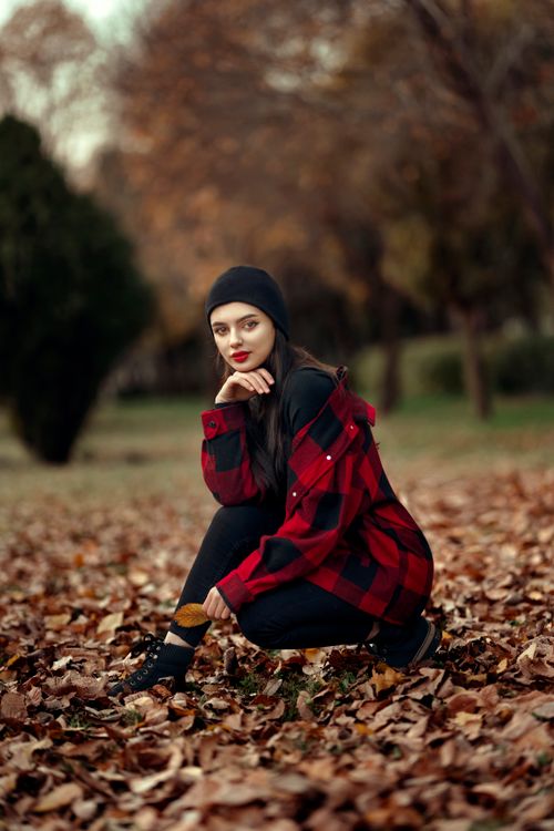 Free Portrait of a young woman wearing flannel in a park during fall in Erbil, Iraq. Stock Photo