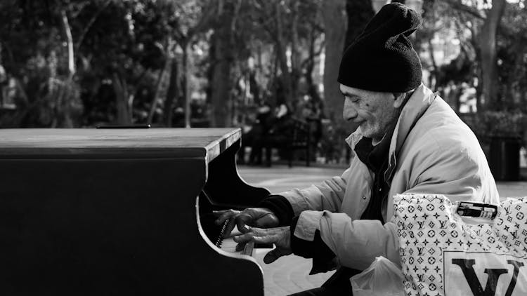 Elderly Man Playing On Piano In Park