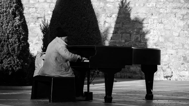 Elderly Man Playing On Piano In City