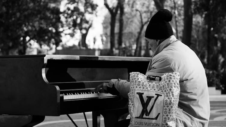 Elderly Man Playing On Piano In Urban Park