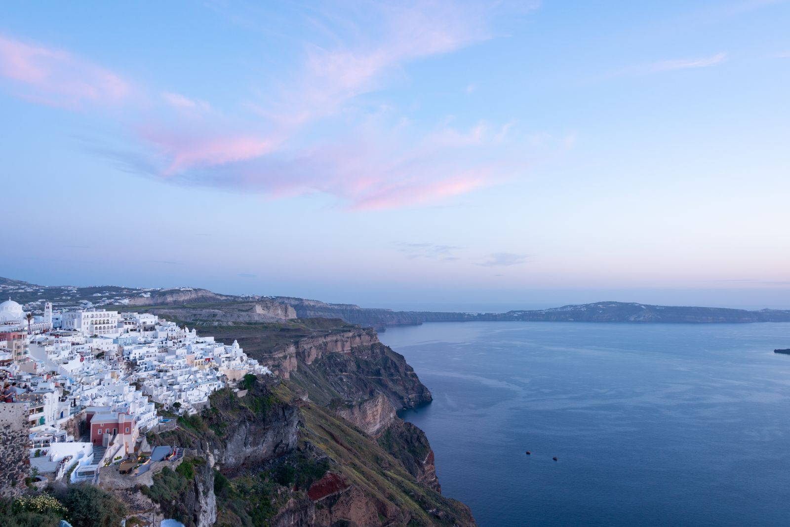 Stunning Santorini cliffside town and seascape at twilight showcasing iconic Greek architecture.