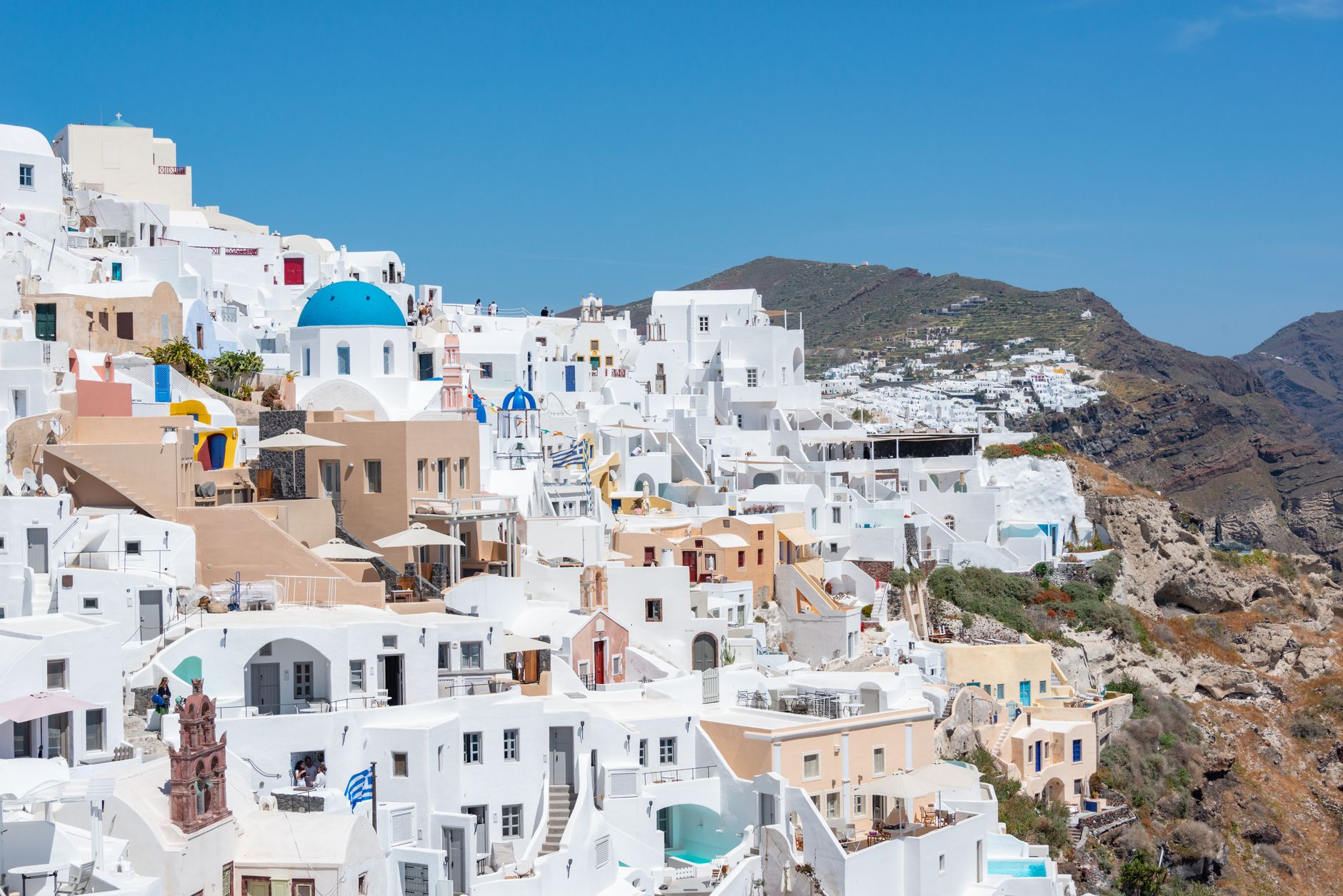 View of iconic whitewashed buildings and blue domes of Santorini, Greece.