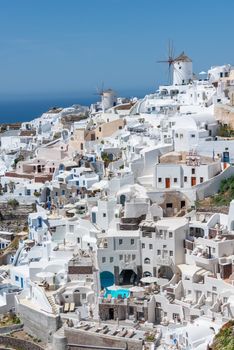 A breathtaking view of Santorini's classic white buildings with a backdrop of the sea and windmills.
