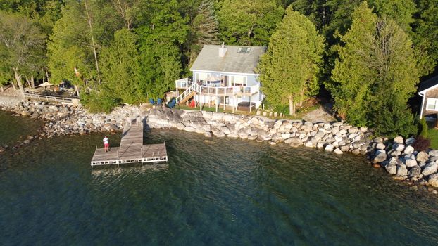 Picturesque lakeside house with a wooden dock on a sunny day in Meaford, Ontario.