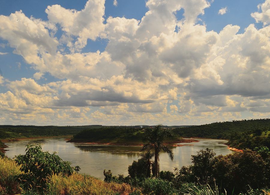 Breathtaking river view with lush greenery under a dramatic sky in Wanda, Argentina.