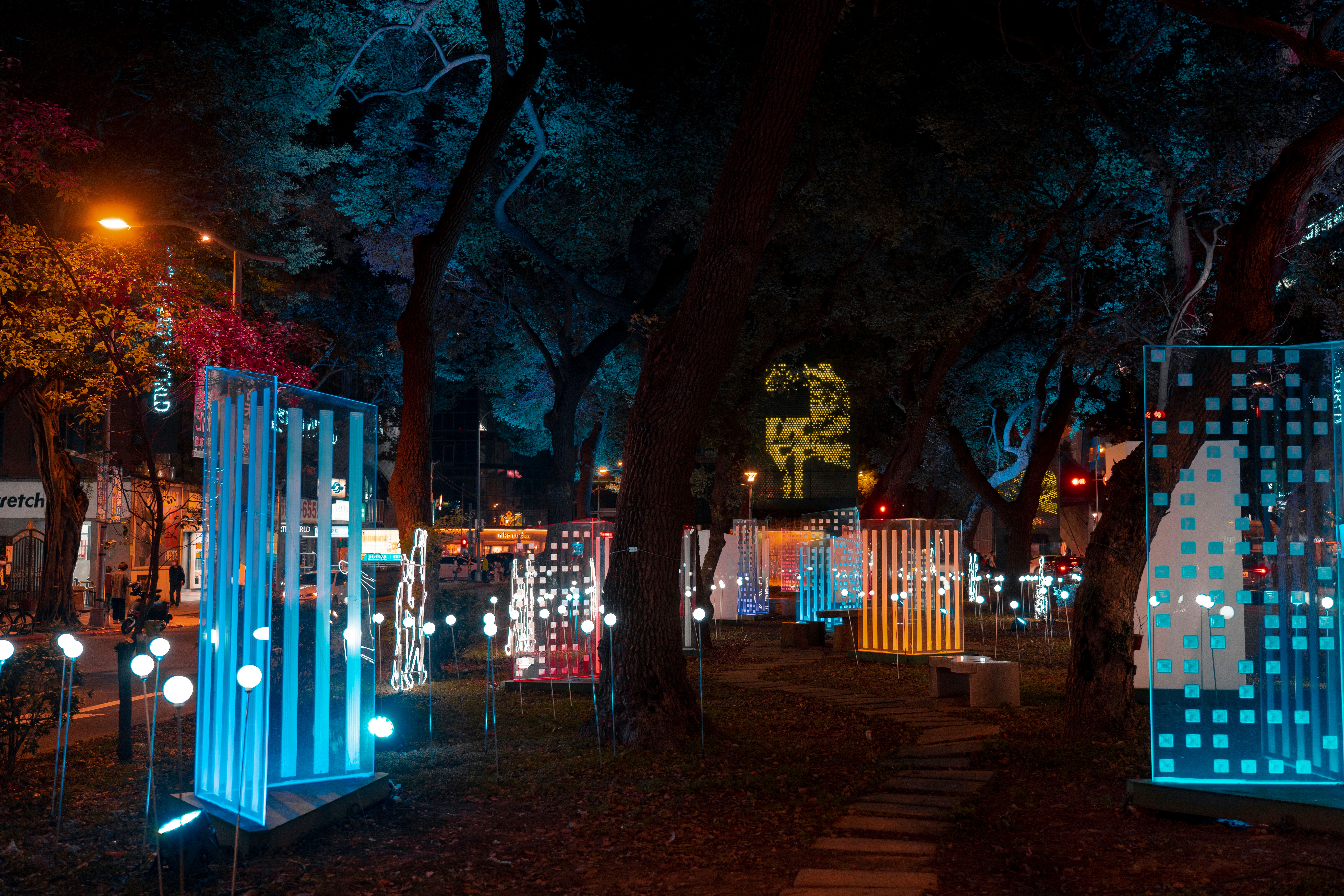Colorful illuminated art installation in an urban park at night, showcasing modern design.