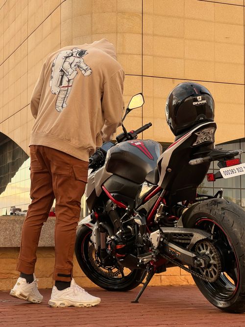 Free Man in casual attire standing by his parked motorcycle in Ouled Fayet, Algeria. Stock Photo