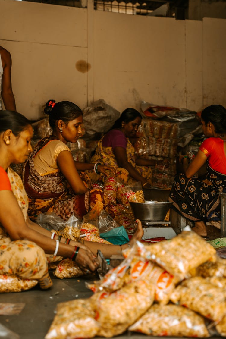 Women In Traditional Clothes Cooking Sitting On Floor