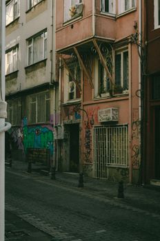 A narrow urban alleyway showcasing colorful graffiti on weathered buildings.