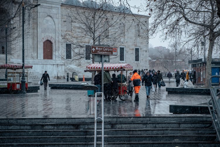 People Walking On City Square In Snow