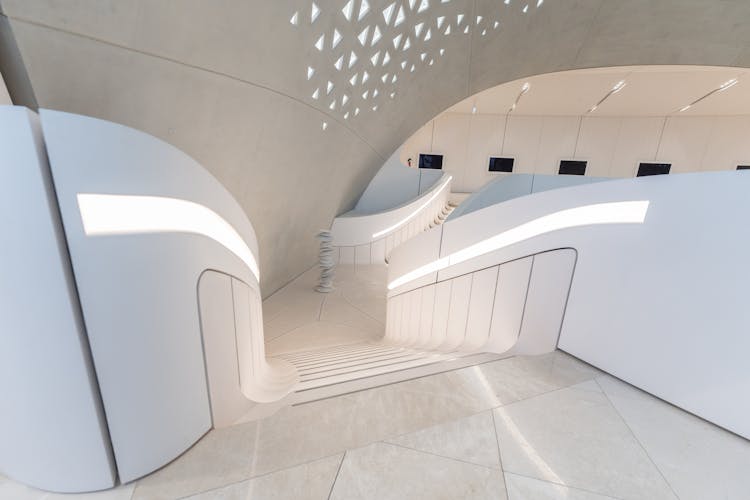 Stacked Stones Behind Stairs Among White Walls