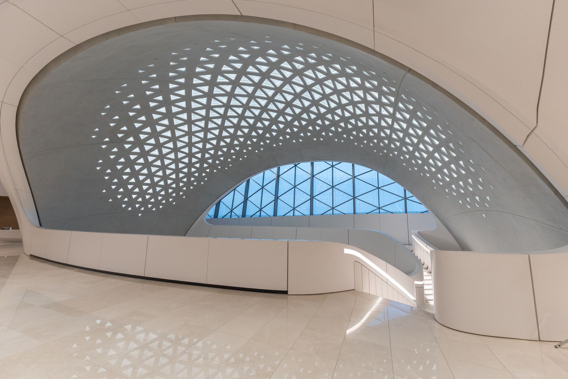 Elegant interior with a geometric ceiling and natural light in a modern architectural space.