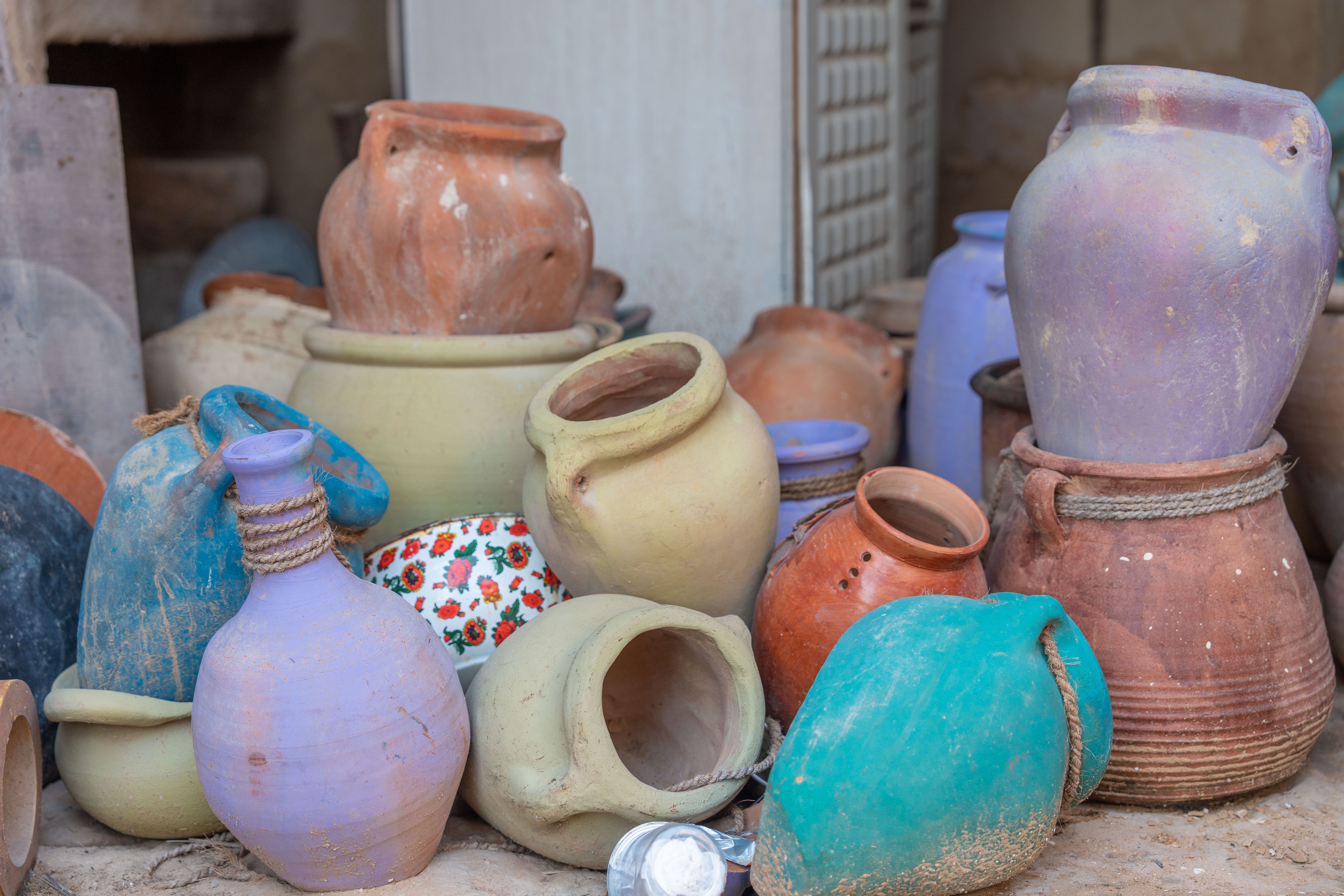 Assortiment vibrant de pots en terre cuite exposés en extérieur, montrant des tons terreux et des textures rustiques.