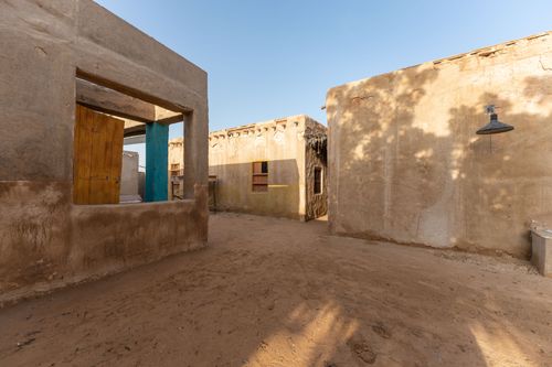 Free Explore a quiet desert townscape featuring traditional earthen buildings under a clear sky. Stock Photo