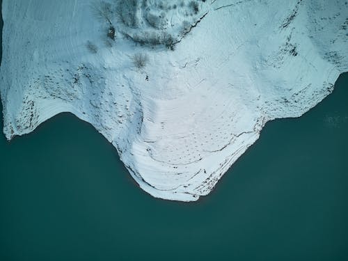 Aerial Photography of a Snow Covered Mountain and a Coast 