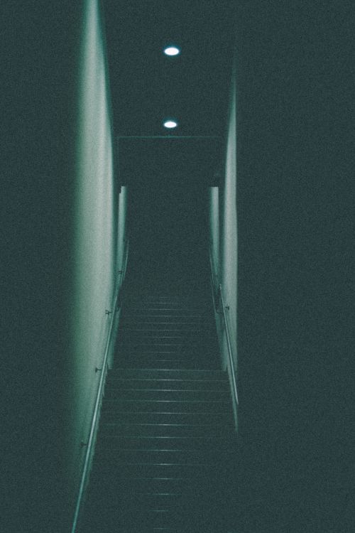 Free Moody and mysterious staircase with overhead lights in a narrow corridor. Stock Photo