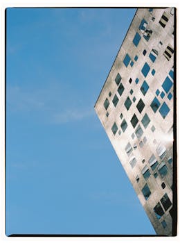 Futuristic building facade reflecting sunlight on a clear day in Tbilisi, Georgia.