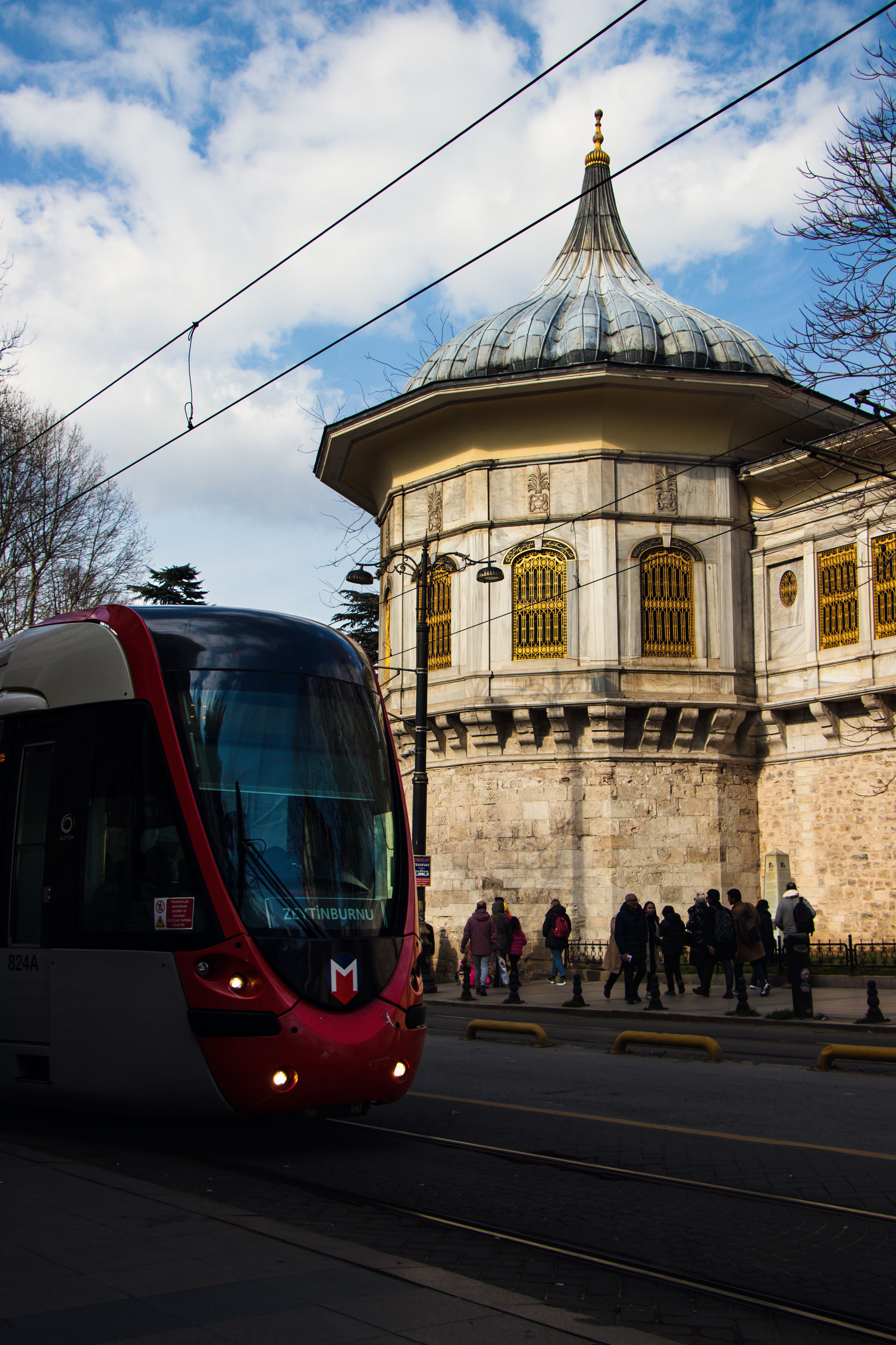 A tram travels past an Ottoman landmark in Istanbul, capturing urban life.