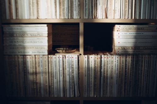 Free A sunlit bookshelf with neatly arranged books and an ashtray in a cozy Istanbul home. Stock Photo