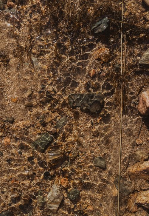 Free A detailed view of rocks and pebbles under clear water, creating a natural pattern. Stock Photo