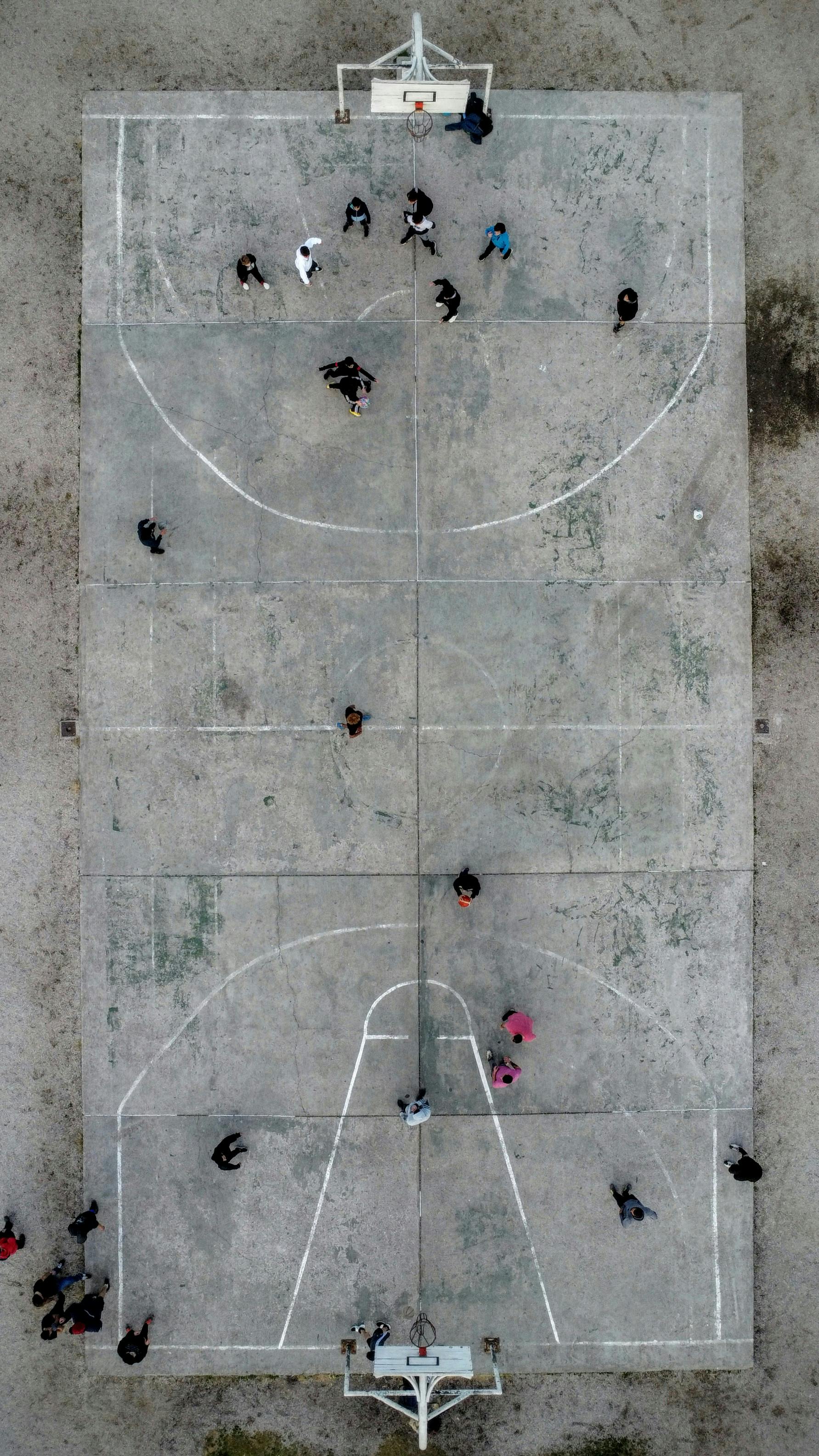 Top-down drone view of a basketball game on an outdoor court in Argentina.