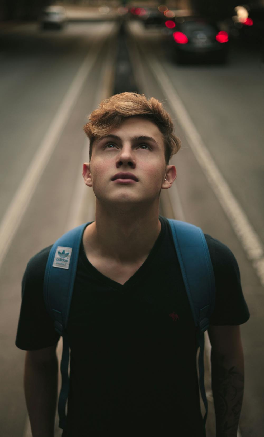 Young man standing in the middle of the road. | Photo: Pexels
