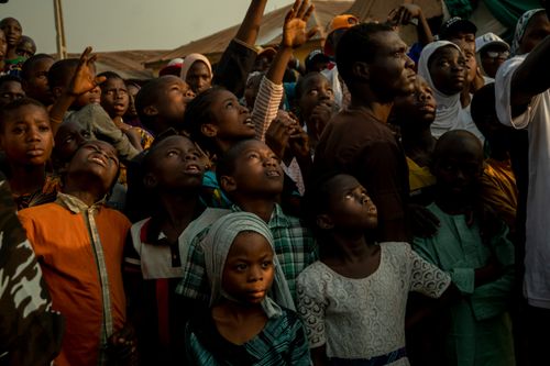 Free A diverse crowd of African children and adults looking upwards during a community gathering in Cape Town, South Africa. Stock Photo