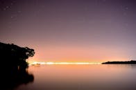 在阿根廷坎德拉里亚的夜晚，湖畔景色宁静，平静的水面倒映着城市的灯光