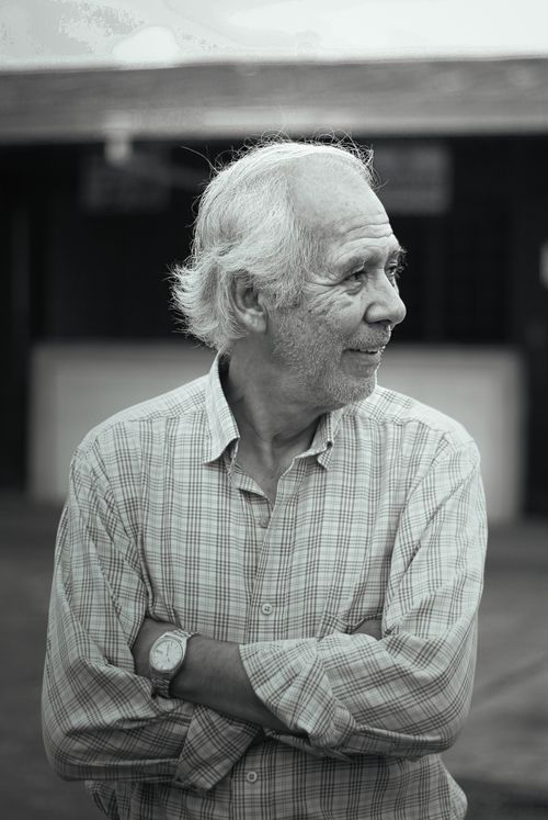 Free Senior man with gray hair smiling, looking away in a black and white portrait. Stock Photo