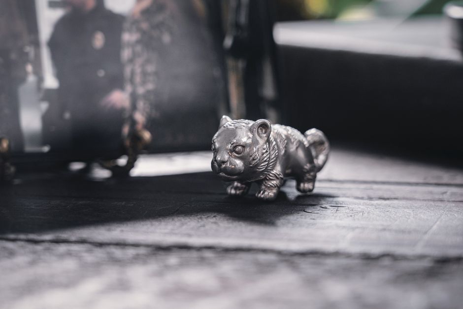 Detailed photo of a metallic tiger figurine with a gray background, providing a modern and artistic feel.