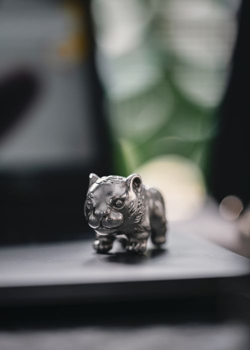 Free Close-up of a shiny metal tiger figurine highlighting intricate details in a soft focus setting. Stock Photo