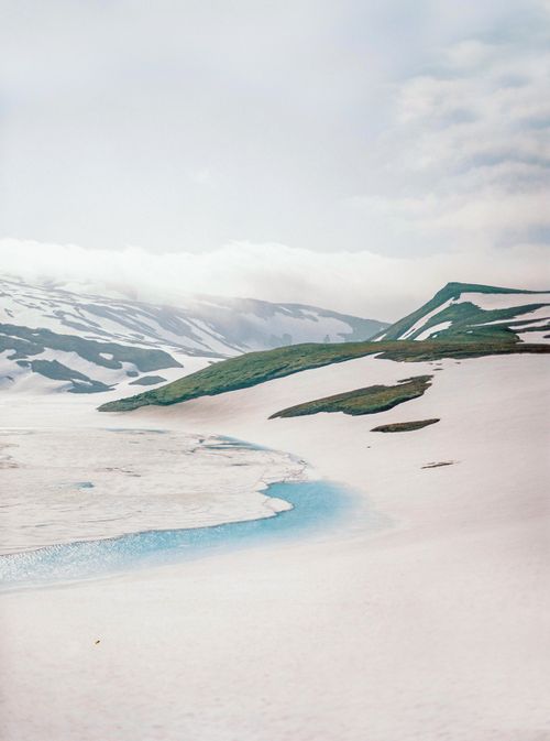 Free Serene winter scene of snow-capped mountains and icy rivers in Kamchatka, Russia. Stock Photo